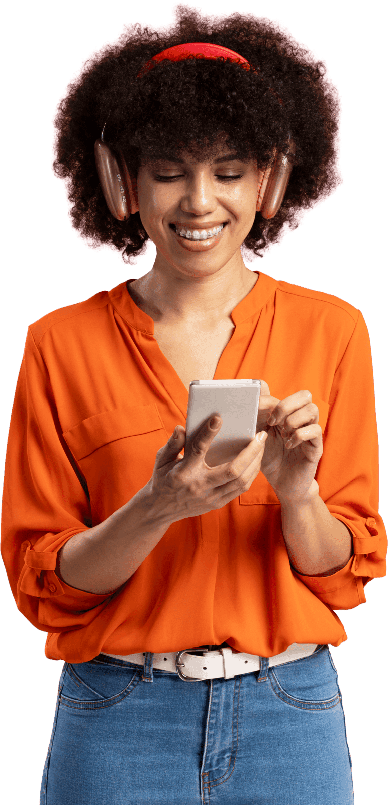 Confident creator wearing headphones and an orange top, checking her phone, cut out on a transparent background, standing over the red graphic block